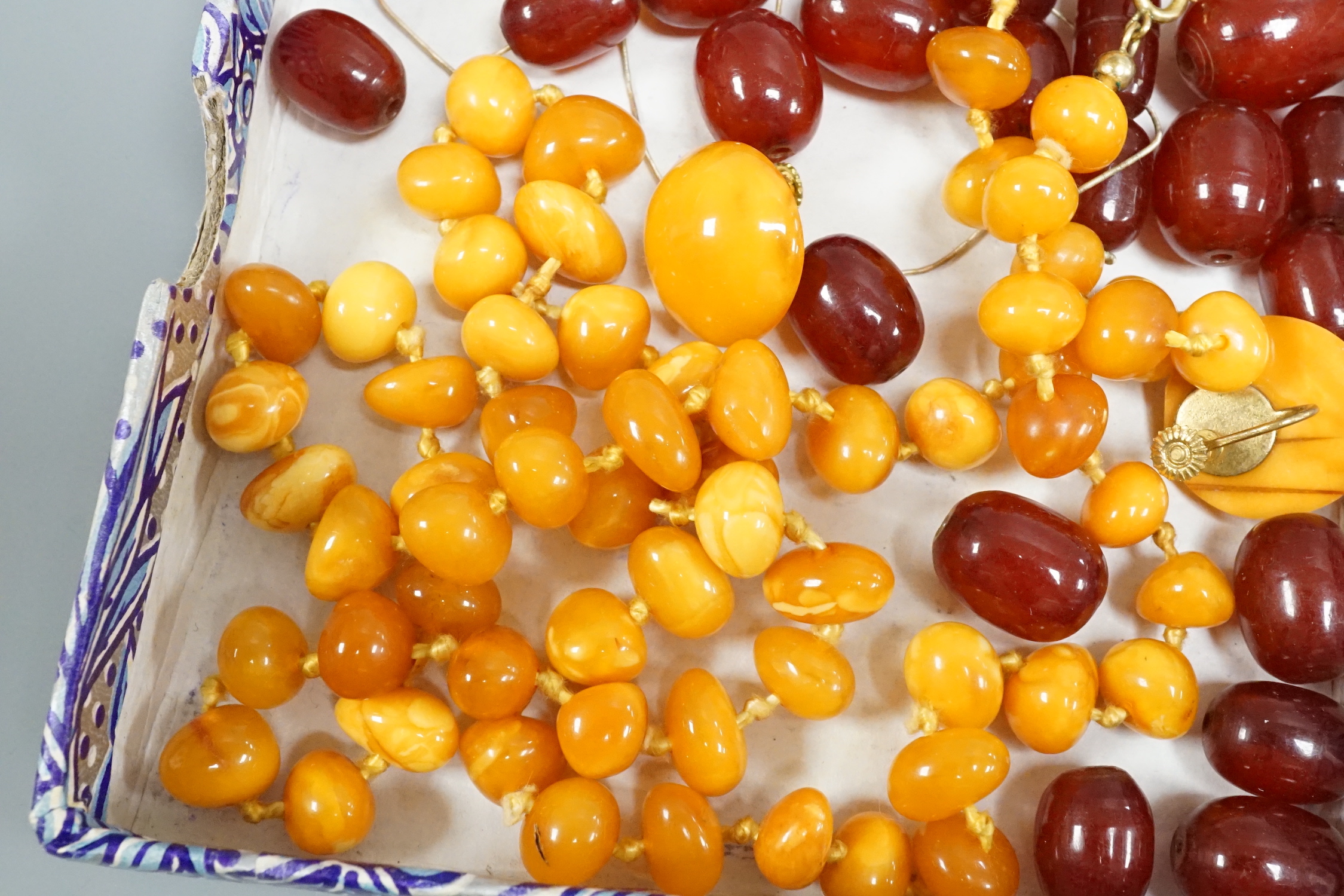A single strand amber necklace, par of amber earrings and an amber pendant?(lacking fitting), gross weight 40 grams, together with a small quantity of loose simulated cherry amber beads.